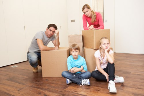 Professional movers carrying furniture in a Bayswater apartment building